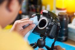 Person cleaning camera sensor with a cloth.