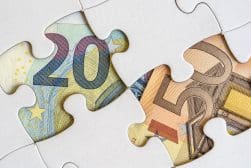 Two puzzle pieces fit together, each featuring parts of a 20 and 50 euro banknote, illustrating the concept of financial integration.