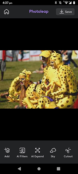A group of people dressed in yellow and black spotted costumes poses together outdoors.